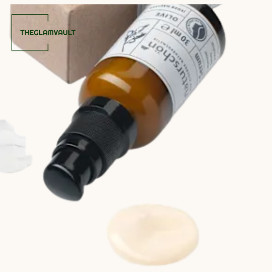 Skincare bottle with dropper and sample on a white background, branded 'THEGLAMVAULT'.