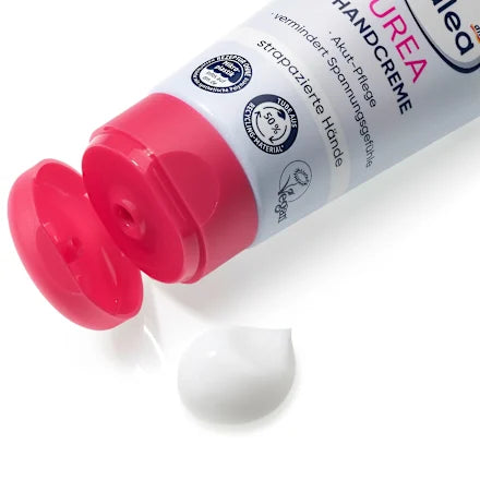Hand cream tube with red cap on a white background